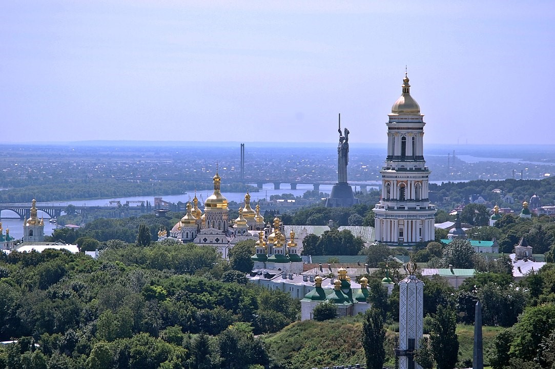 Das auf den Hügeln des Westufers des Dnepr gelegene Höhlenkloster und die Mutter-Heimat-Statue, dahinter der Dnepr und dessen flaches Ostufer